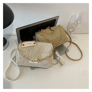 Détail de sacs à bandoulière en paille tressée avec chaînes dorées et bandoulières
