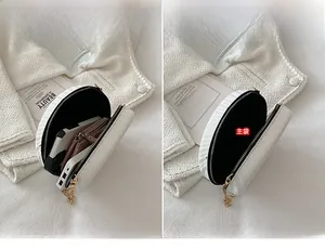 Vue détaillée du compartiment intérieur pour téléphone dans ce petit sac rond blanc