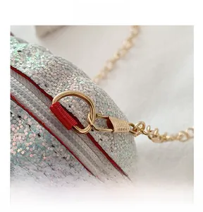 Close-up of silver sequin shell bag with red zipper edge and gold chain hardware
