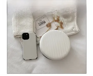 Comparaison de taille détaillée du sac rond blanc à chaîne avec smartphone et texture rayée