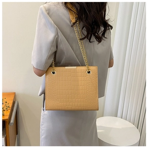 Detailed view of light brown crocodile pattern tote bag with golden chain straps