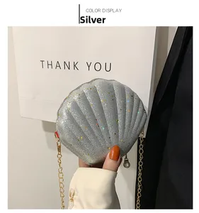 Detailed shot of silver shell bag featuring colorful sequins and pearl zipper charm