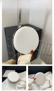Détail du sac rond blanc avec texture ondulée et bandoulière en chaîne dorée