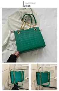 Dettaglio borsa tote verde coccodrillo con catena dorata e finiture metalliche