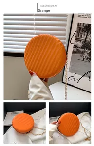 Vue détaillée du sac rond orange avec textures verticales et bandoulière en chaîne dorée