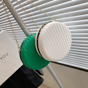 Détail de sacs ronds en cuir PU avec chaîne en vert et blanc et plis verticaux