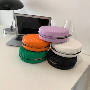 Détail montrant cinq mini sacs ronds colorés avec une texture à rainures verticales