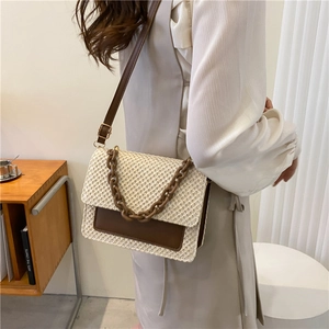 Sac bandoulière tissé en paille avec rabat en cuir marron et chaîne décorative