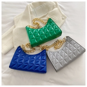 Detailed overhead view of quilted leather bags in green blue and grey with gold chains