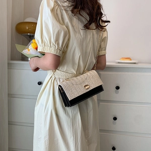 Sac bandoulière élégant en paille et cuir noir avec chaîne dorée et boucle métal