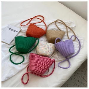 Close-up of handmade woven bucket bags featuring elegant large pearl closure accents