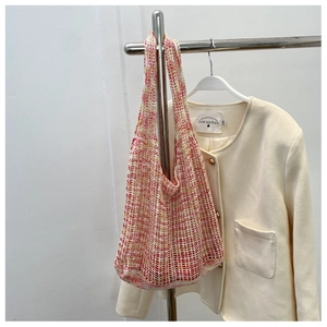 Detail der rot-gelben Stricktasche mit kunstvoller Mesh-Häkelstruktur und Textur