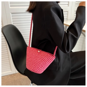 Detail of pink hand-woven bucket bag with pearl closure and striped knit pattern