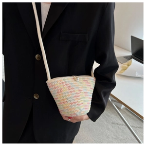 Detail of woven crossbody bag with colorful wavy embroidery and a pearl button closure