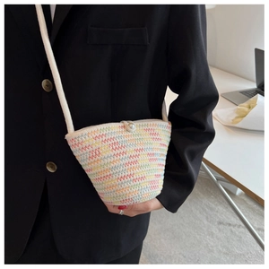 Detail of colorful zigzag woven bucket bag featuring pearl closure on black blazer