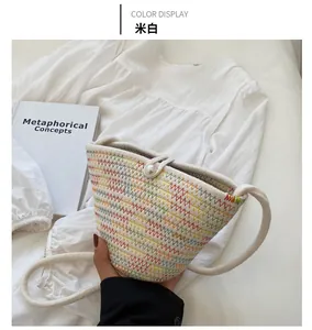 Detail of off-white woven bucket bag featuring colorful zigzag patterns and pearl closure