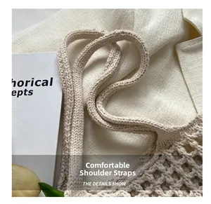 Dettaglio della tracolla larga e comoda sulla borsa in maglia beige all'uncinetto