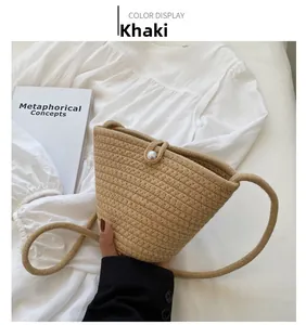 Detail of khaki woven bucket bag with thick texture and elegant pearl buckle decor
