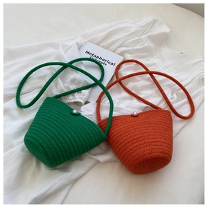Detail of hand-woven bucket bags in green and orange with pearl button closures