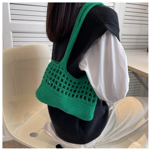 Dettaglio borsa a tracolla in cotone verde tessuta a mano con design in maglia traforata