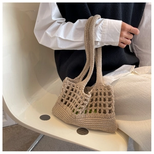 Dettaglio della borsa tote beige all'uncinetto con trama traforata e stile drappeggiato