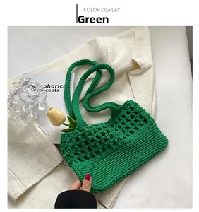 Dettaglio della borsa a maglia verde con trama traforata e tracolla lunga in cotone