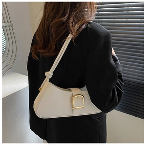 Close-up of white crescent underarm bag with gold buckle on a black blazer