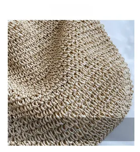 Detailed close-up showing the intricate woven texture of the beige straw tote bag