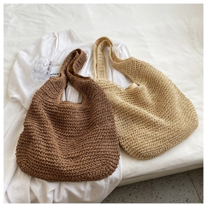 Close-up of woven straw tote bags in brown and beige showing detailed texture
