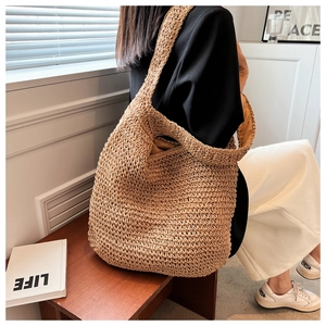 Detail of a handmade straw tote bag featuring intricate weave and ergonomic wide shoulder strap