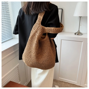 Detail of a large brown handmade woven tote bag with wide straps for shoulder carry