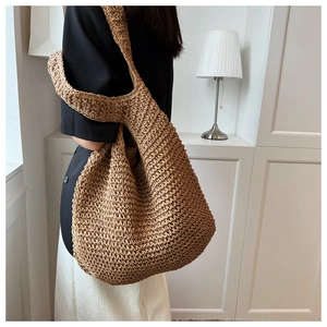 Close-up of a large handmade woven shoulder bag with hollow crochet texture on model