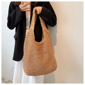 Minimalist woven straw bucket bag with fabric lining shown on a model in khaki