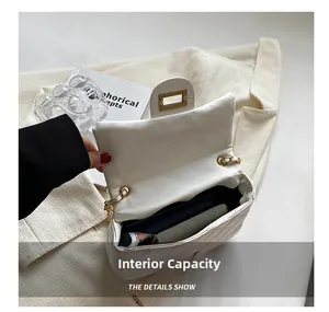 Detail showing the interior capacity and beige lining of the quilted white chain bag
