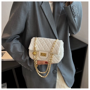 Detail of white quilted flap bag with gold chain strap and metal ball decoration