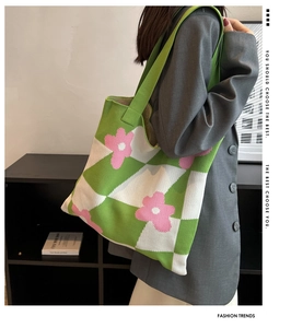 Detail view of knitted tote bag featuring green checkered pattern with pink flowers