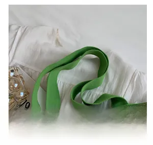 Detail of wide green knitted handle with floral texture on a vintage tote bag