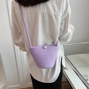 Light purple hand-woven bucket bag with a pearl clasp and slender shoulder strap