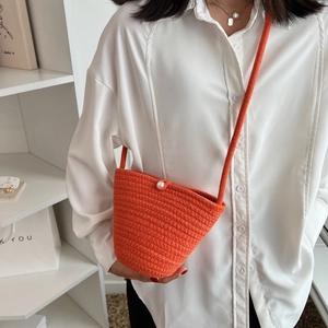 Handmade orange woven shoulder bag with large pearl detail for women in minimalist style