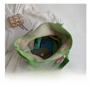 Interior view of knitted tote bag showing capacity with phone, wallet, and skincare item