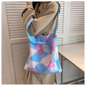 Detail of blue checkerboard knit tote bag with pink flower embroidery and wide strap