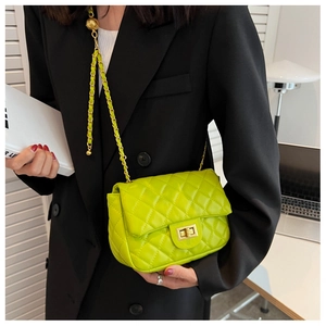 Detail of neon green quilted crossbody bag with gold chain strap and metallic twist lock