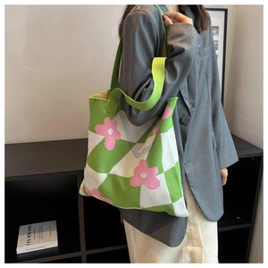 Detail of green and white checkered knit tote bag with 3D pink floral pattern embroidery