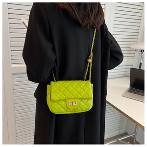 Detail of green quilted bag with golden chain and adjustable gold ball charm