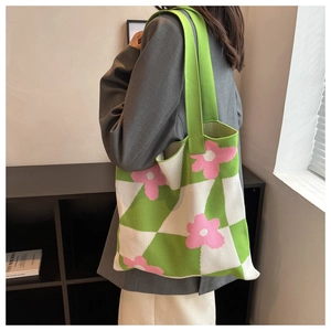 Detail of green and white checkerboard knit tote bag with pink floral pattern