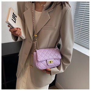 Detail of light purple quilted handbag with gold hardware and metal ball chain