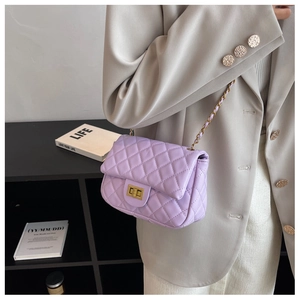 Close-up of lavender quilted leather chain bag worn with a beige blazer for women