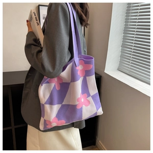 Close-up of knit tote bag featuring purple checkerboard and pink floral pattern