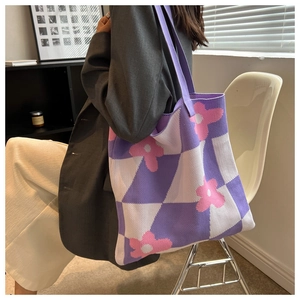 Close-up of purple checkerboard knitted tote bag with pink flower patterns and texture
