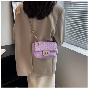 Detail of light purple quilted shoulder bag featuring gold chain and turn-lock closure